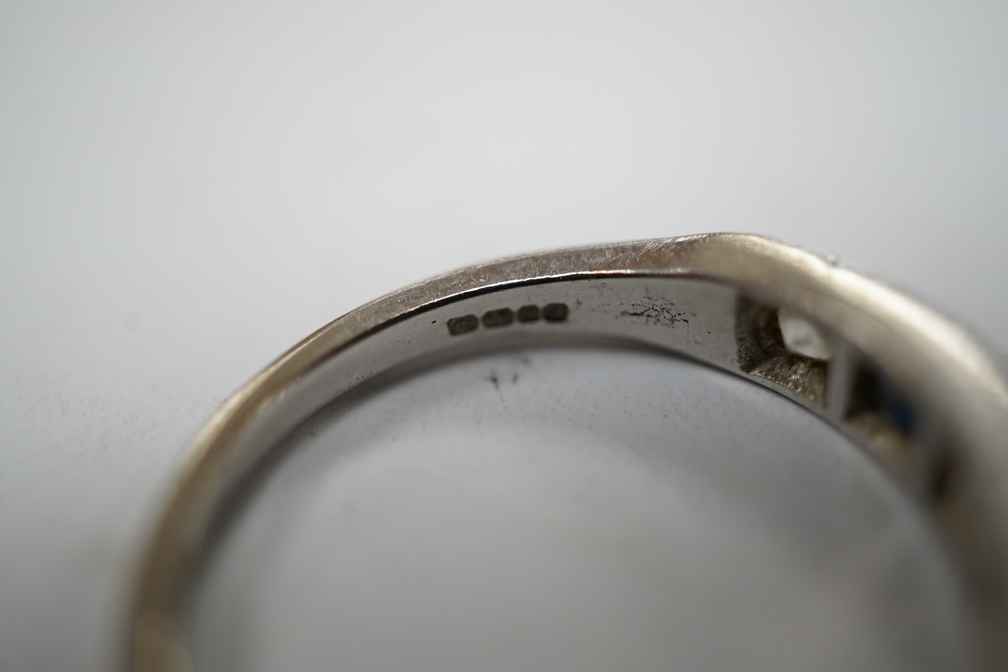 A 1970's 18ct white gold, sapphire and simulated diamond set half hoop ring, size O, gross weight 3.5 grams. Condition - fair